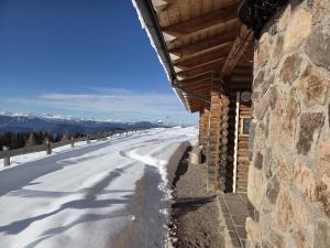 a snow covered road next to a building at Freddie house in Albiano
