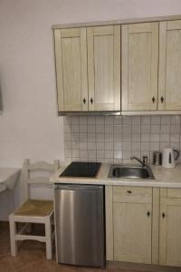 a kitchen with wooden cabinets and a sink at SEA HOME Accommodation in Loutraki