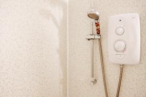 a shower with a shower head on a wall at Self-catering Lighthouse Keeper's Cottage on the NC500 in Wick +82 photos