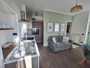 a kitchen and living room with a sink and a couch at Casa Milda in Sanremo