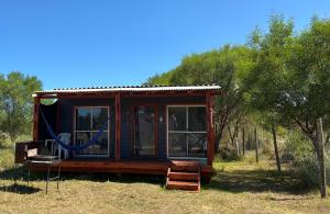 eine kleine Hütte auf einem Feld mit Bäumen in der Unterkunft Glass in Punta Del Diablo