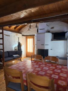 a living room with a table and chairs and a couch at Rustico Indéman in Gambarogno
