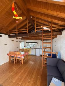 a living room with a table and a kitchen at Rustico Indéman in Gambarogno