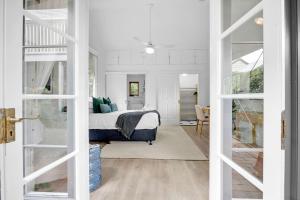 a bedroom with a bed and a room with a window at 4 Bed Queenslander City Views Walk to Suncorp Deck + Parking in Brisbane