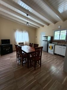 a dining room with a table and chairs and a kitchen at Cabañas EL VALLE in Villa Rumipal