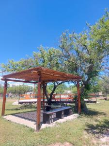 a picnic shelter in a park with a tree at Cabañas EL VALLE in Villa Rumipal