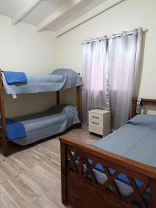 a bedroom with two bunk beds and a window at Cabañas EL VALLE in Villa Rumipal