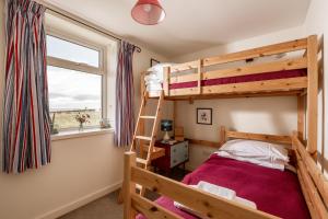 a bedroom with a bunk bed and a window at Self-catering Lighthouse Keeper's Cottage on the NC500 in Wick