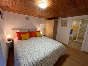 a bedroom with a bed with yellow and red pillows at A LA BELLE EPOQUE in Épernay
