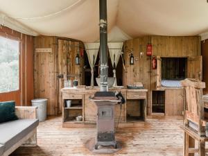 a room with a stove in the middle of a room at 6-person Duynlodge Tent in Callanstoog in Callantsoog
