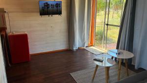 ein Raum mit zwei Tischen und einem Fernseher an der Wand in der Unterkunft Glass in Punta Del Diablo + 36 Fotos