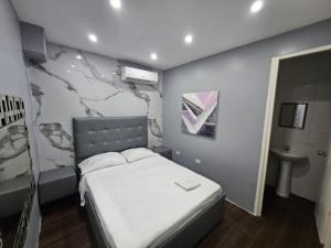 a small bedroom with a bed and a sink at Hotel Residencial La Malvarrosa in Panama City