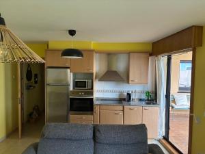 a living room with a couch in a kitchen at Acogedor apartamento con terraza in Cedeira