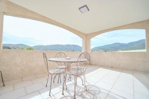 a table and chairs in a room with mountains at La ferme in Moltifao