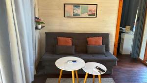 ein Wohnzimmer mit einer Couch und zwei Tischen in der Unterkunft Glass in Punta Del Diablo