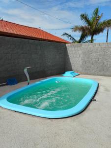 a large blue swimming pool on the side of a house at Aconchego Maria Laura in Palhoça