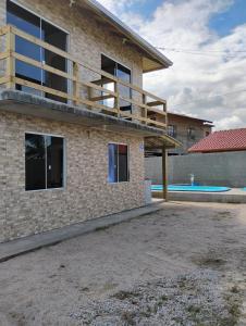 a house with a balcony and a swimming pool at Aconchego Maria Laura in Palhoça