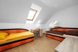 a bedroom with two beds and a desk and a table at Apartmán Regina in Liberec