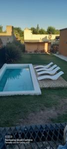 ein Swimmingpool mitten im Garten in der Unterkunft DUPLEX ATARDECERES in Chascomús