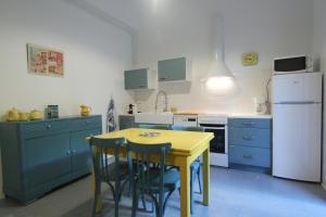 a kitchen with a yellow table and blue cabinets at Le 27 in Perpignan