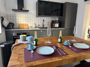 a kitchen with a wooden table with plates and wine glasses at AhA in Lingen