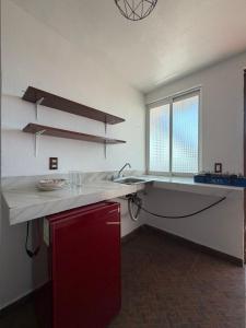 eine Küche mit einer Arbeitsfläche mit Spüle und einem Fenster in der Unterkunft Apartamento 32 in Toluca de Lerdo
