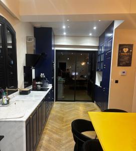 a kitchen with blue cabinets and a yellow counter top at Apartment with terrace Mérignac in Mérignac