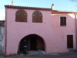 a pink building with a motorcycle parked in it at Casa Roberta in Martis
