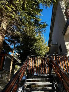eine Treppe, die zu einem Haus mit einem Holzzaun hinaufführt in der Unterkunft Vila Bon in Tetovo