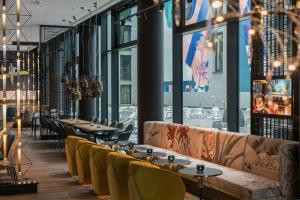 a restaurant with tables and chairs and large windows at Motel One Berlin-Alexanderplatz in Berlin +40 photos
