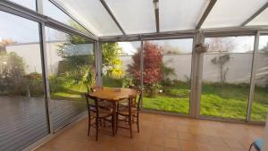a screened in porch with a table and chairs in it at Chez Uber in Niort