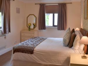 a bedroom with a large bed and a mirror at Rosecraddoc Manor - Lakeview in Saint Cleer +12 photos