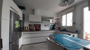 a kitchen with white cabinets and a table and chairs at Chez Uber in Niort