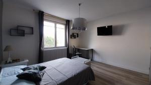 a bedroom with a bed and a large window at Chez Uber in Niort