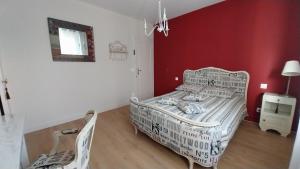 a bedroom with a white bed and a red wall at Chez Uber in Niort