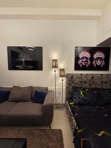 a living room with a couch and posters on the wall at Ajman Central Downtown B-50018 in Ajman 