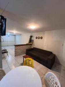 a living room with a couch and a table at Casa Dourada PIPA RN - Sobrado 2 quartos in Pipa