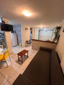 a living room with a couch and a table at Casa Dourada PIPA RN - Sobrado 2 quartos in Pipa