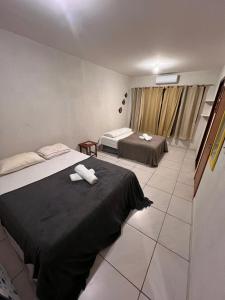 a hotel room with two beds and a window at Casa Dourada PIPA RN - Sobrado 2 quartos in Pipa