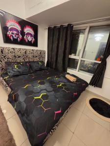 a bedroom with a bed with a black comforter at Ajman Central Downtown B-50018 in Ajman 