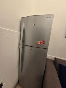 a stainless steel refrigerator in a corner of a room at Ajman Central Downtown B-50018 in Ajman 