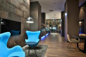 a lobby with blue chairs and a table at Motel One Prague-Florentinum in Prague +21 photos