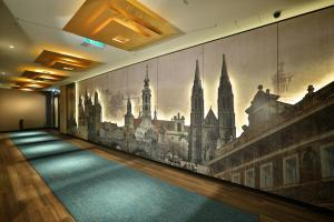 a hallway with a mural of a city on the wall at Motel One Prague-Florentinum in Prague