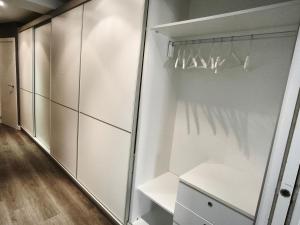 a walk in closet with white cabinets and a glass door at Apartamento Eguzkey - Tolosa centro in Tolosa