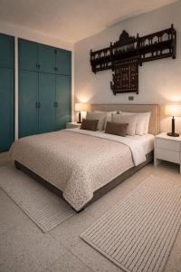 a bedroom with a large bed with blue cabinets at Maison Lella Kmar Sidi Bou said in Sidi Bou Saïd