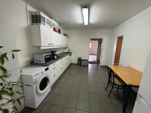 a kitchen with a washing machine and a table at TL Gastzimmer 1 in Frankfurt