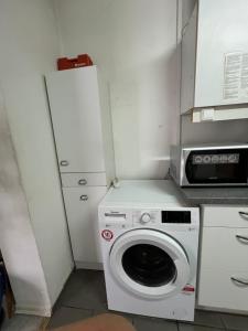 a kitchen with a washing machine and a microwave at TL Gastzimmer 1 in Frankfurt