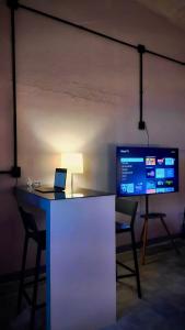 a desk with a laptop and a tv in a room at The Mercedes Room in Oaxaca City +1 photo