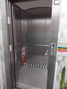 a metal shower with a door in a room at Space in Cochabamba