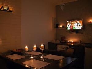 a dining room with a table with candles and a television at Villa Zora in Bardejovské Kúpele